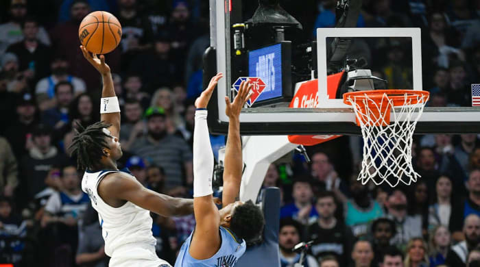 Minnesota Timberwolves guard Anthony Edwards, left, shoots over Memphis Grizzlies forward Xavier Tillman during the first half in Game 4 of an NBA basketball first-round playoff series Saturday, April 23, 2022, in Minneapolis.